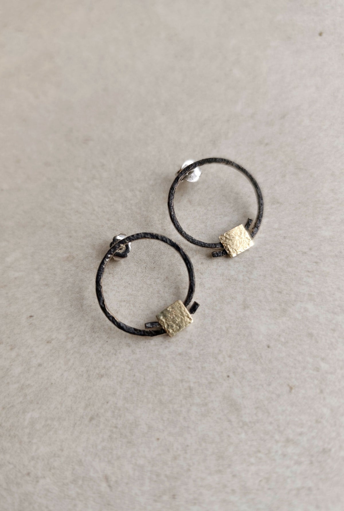 Boucles d’oreilles anneaux noirs, carrés texturés dorés, vue écartée