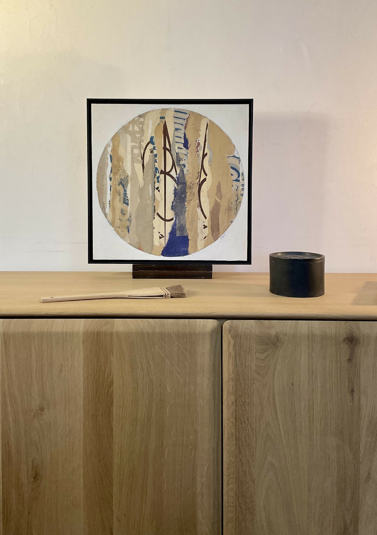 Collage sur bois ARGILE dans cadre noir, composition circulaire abstraite bleu et beige.