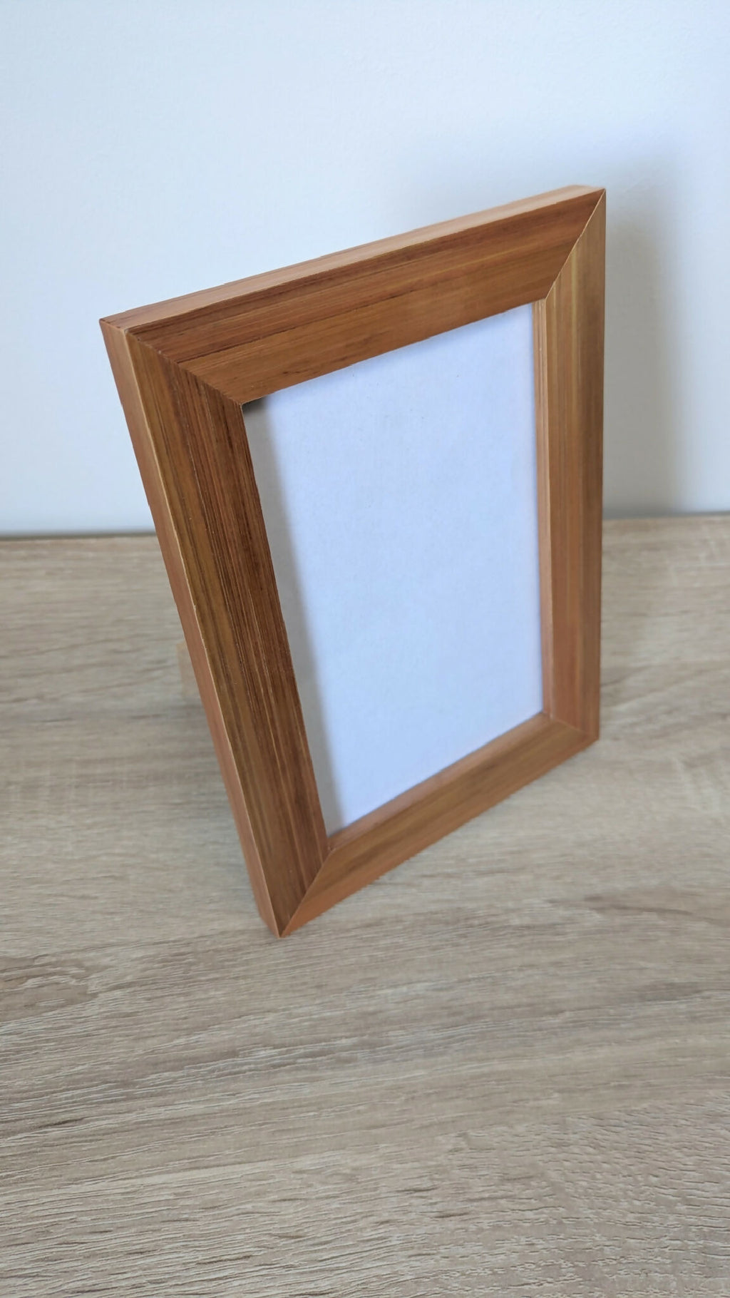 Cadre photo en bois brun à poser, vue de trois quarts