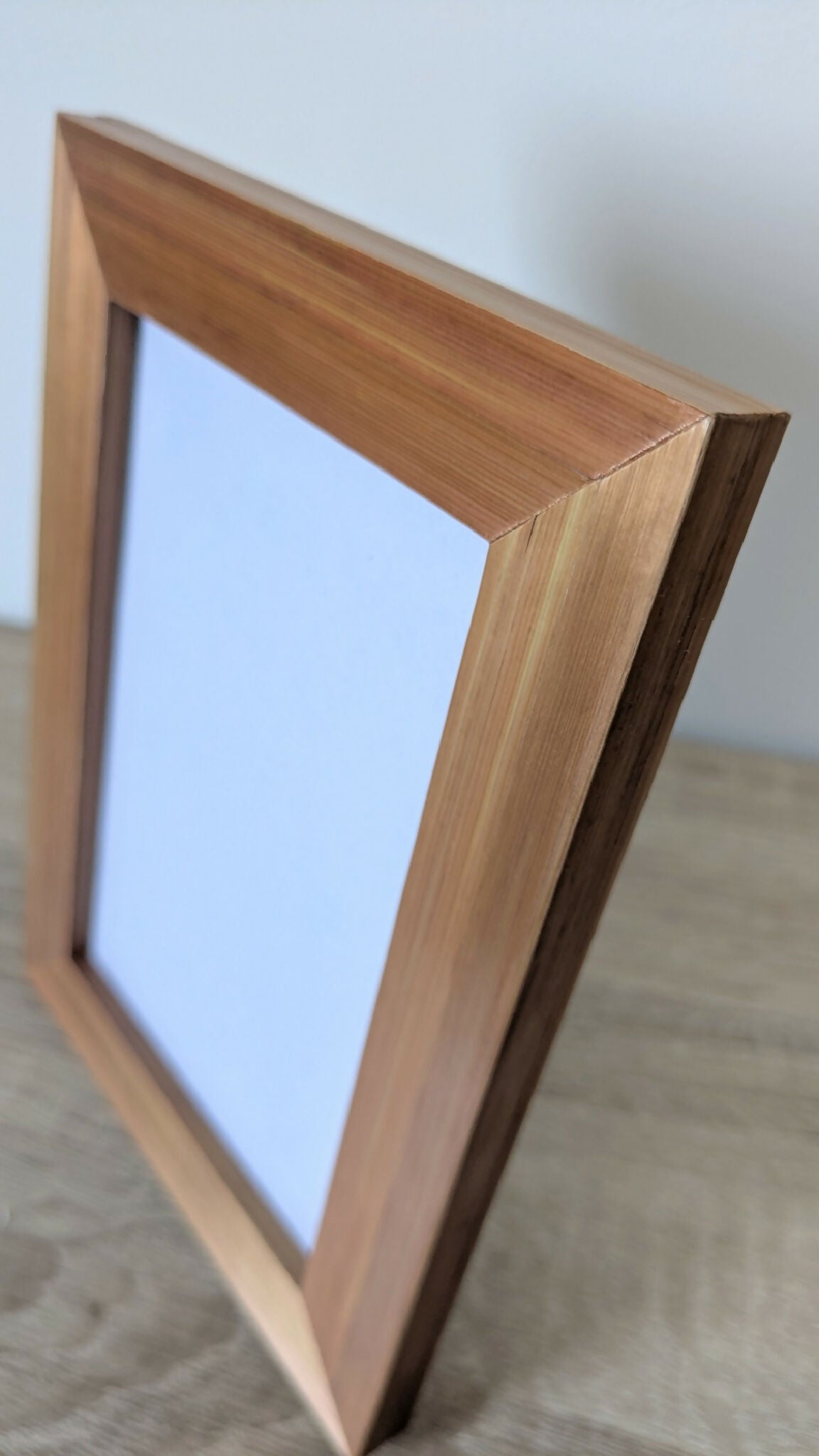 Cadre photo en bois brun, gros plan sur l’angle et le bord de l’encadrement