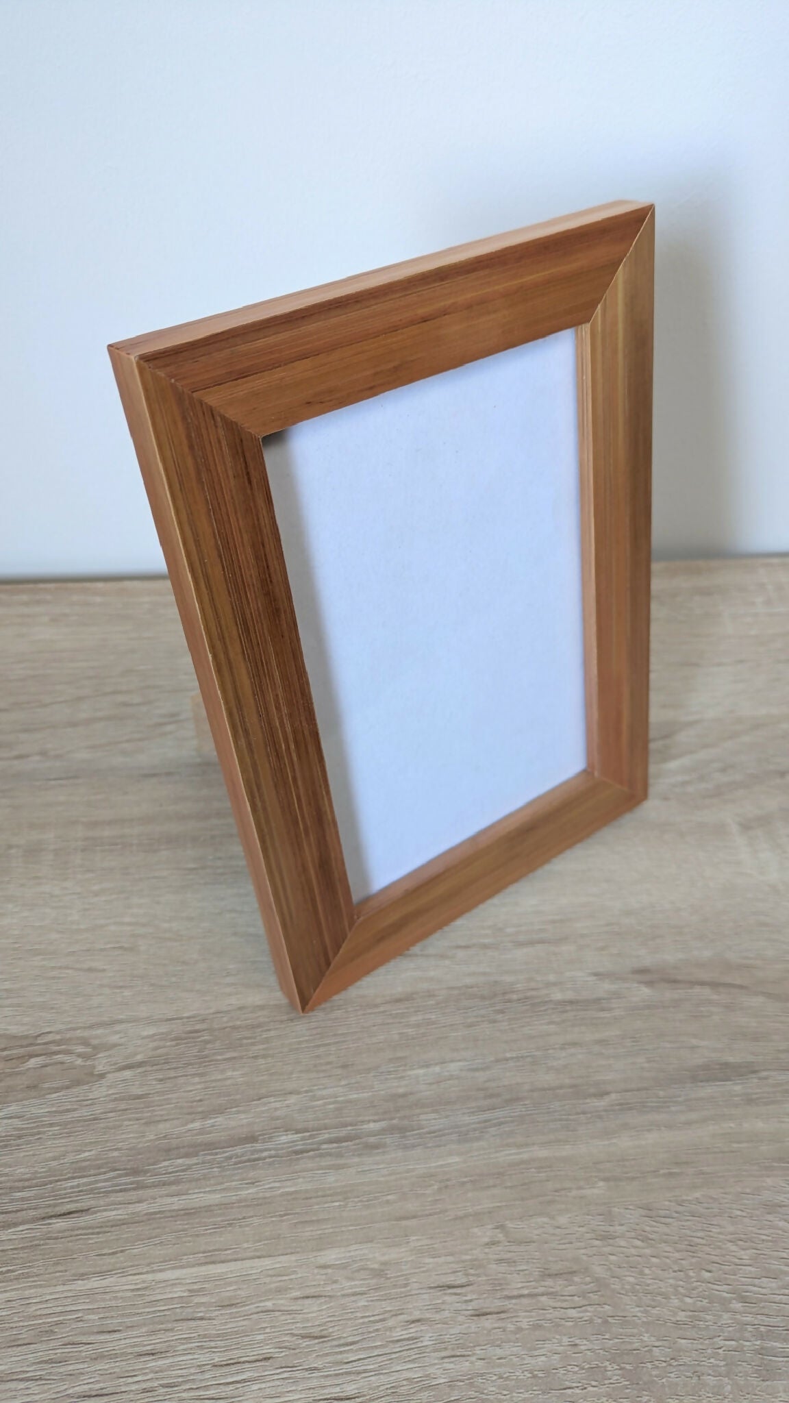 Cadre photo en bois brun à poser, vue de trois quarts