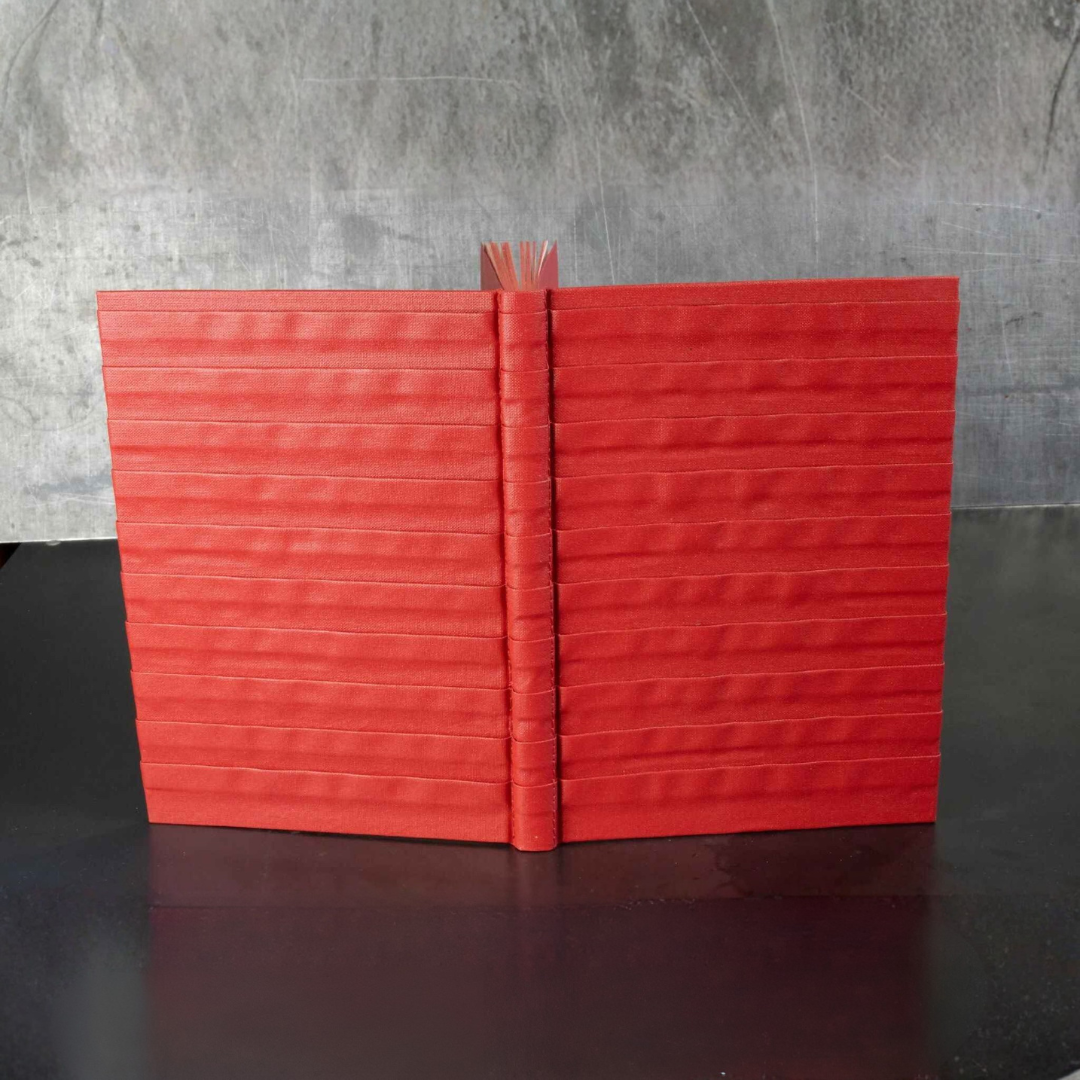 Carnet ou livre d’or rouge à relief, couverture fermée avec dos vertical