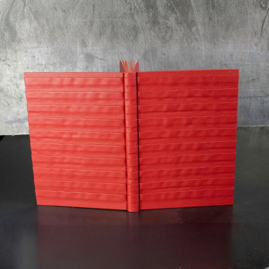 Carnet ou livre d’or rouge à relief, couverture fermée avec dos vertical