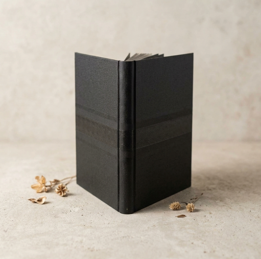 Carnet noir à couverture texturée, pages entrouvertes et dos épais