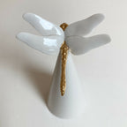 Centre de table cône blanc, motif ailes blanches et tige dorée, vue rapprochée