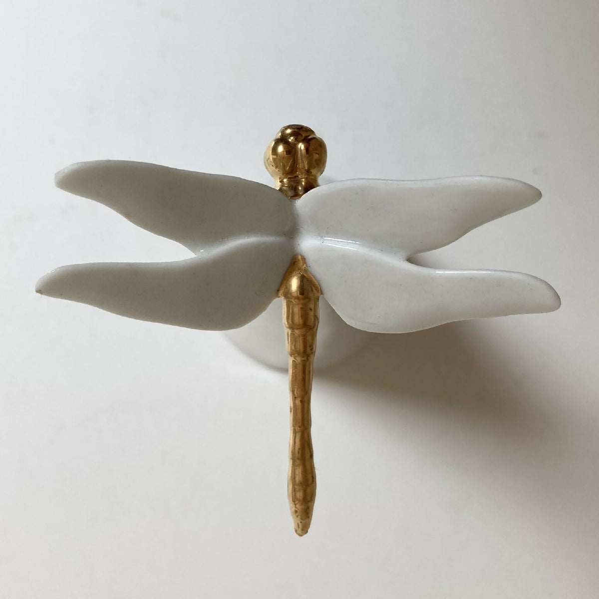 Centre de table cône blanc, motif ailes blanches écartées et tige dorée, vue de face