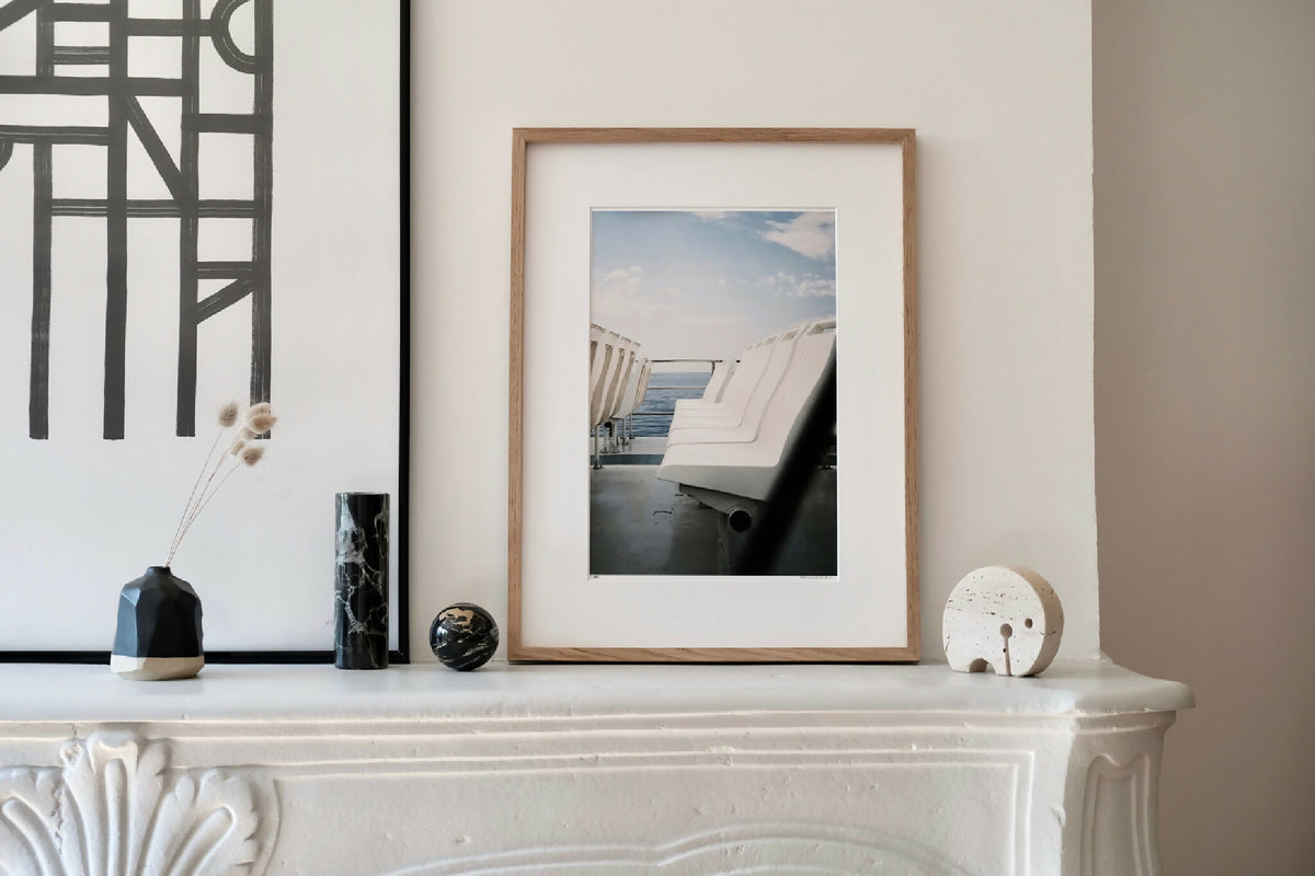 Photo encadrée sur console blanche : chaises longues blanches au bord de mer