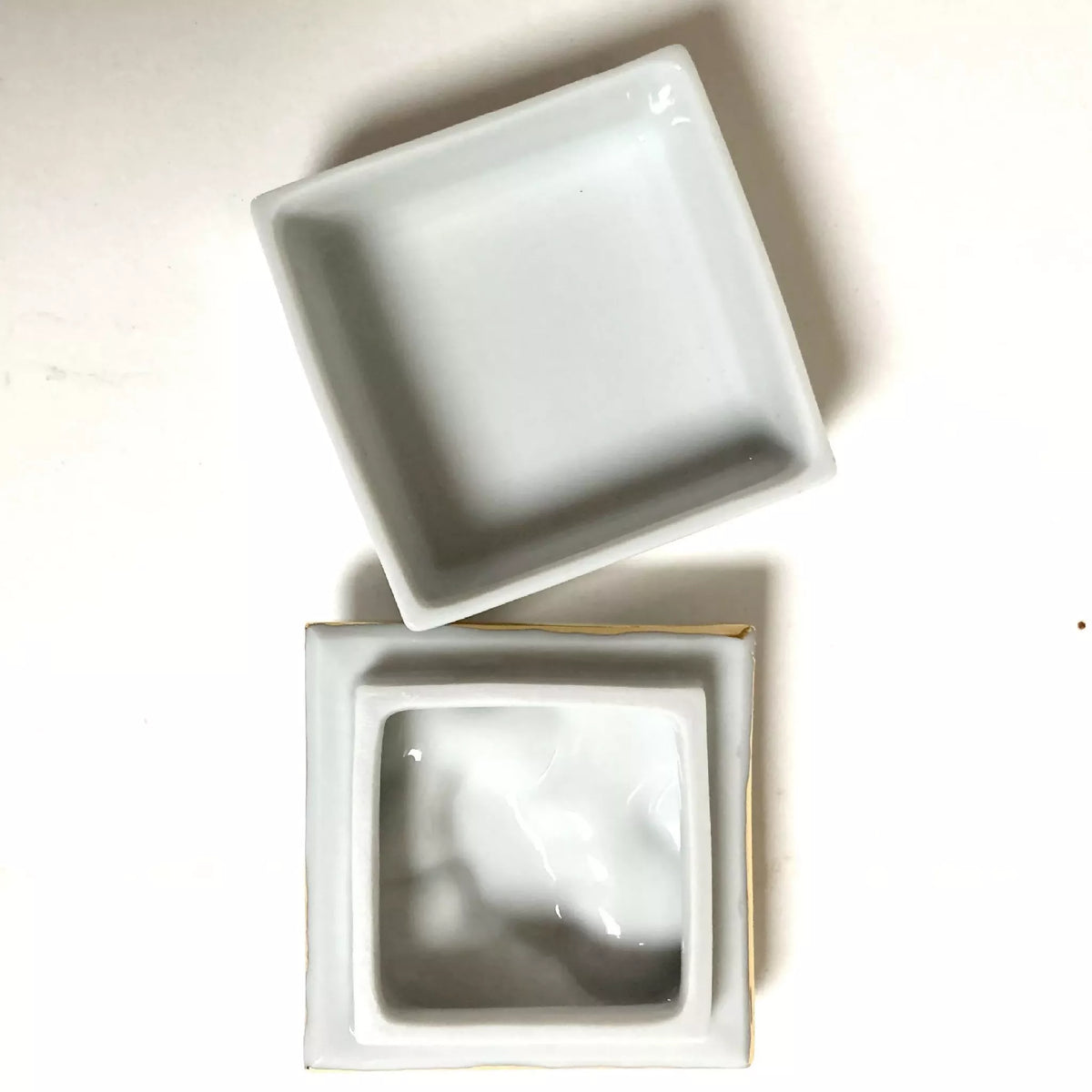 Boîte à bijoux en porcelaine, couvercle ouvert, intérieur blanc avec plateau.