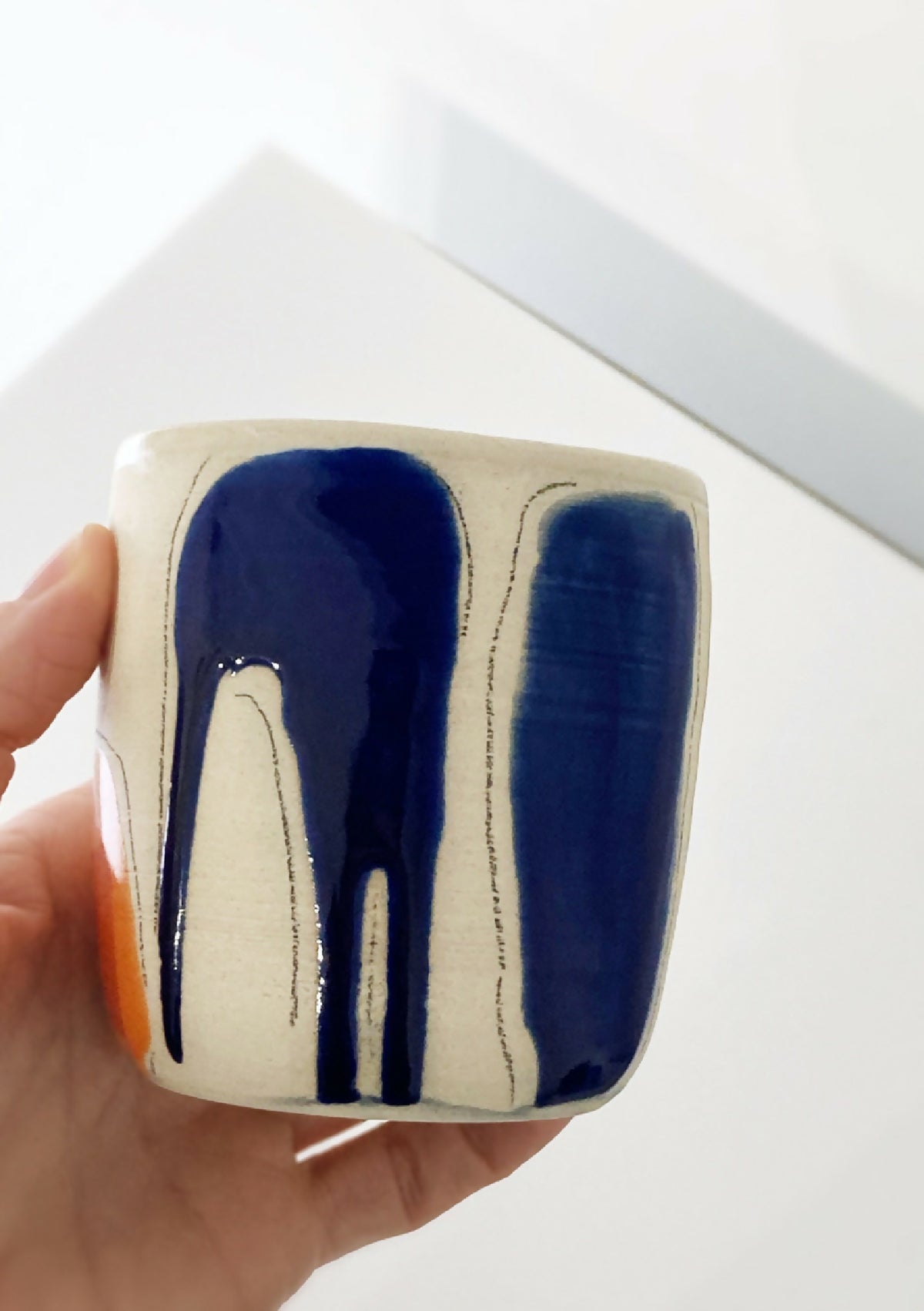 Gobelet en céramique beige, motifs bleu nuit et touche orange