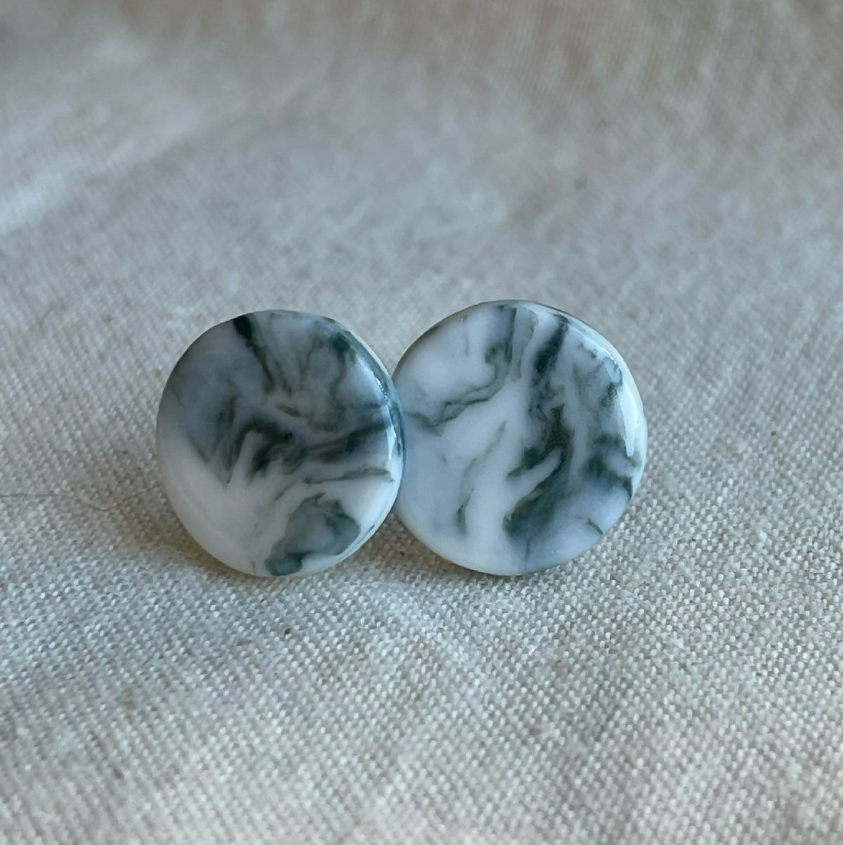 Paire de clous d’oreille en porcelaine blanche à motif marbré gris-bleu