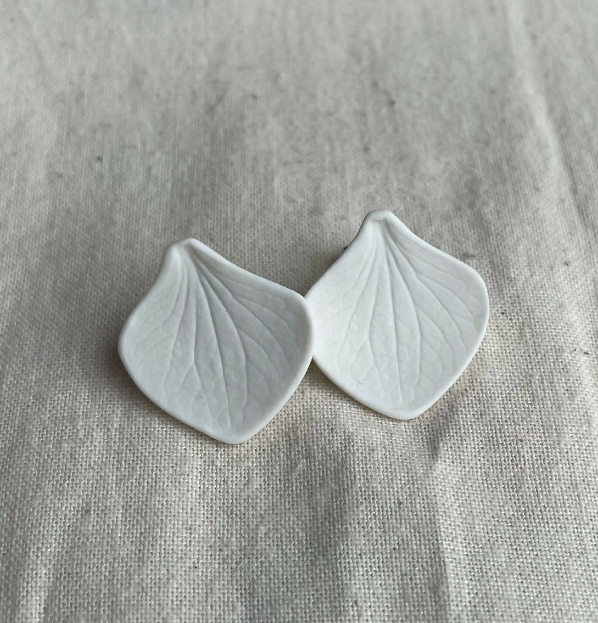 Paire de clous d’oreille en porcelaine blanche, forme pétale, veinage de feuille