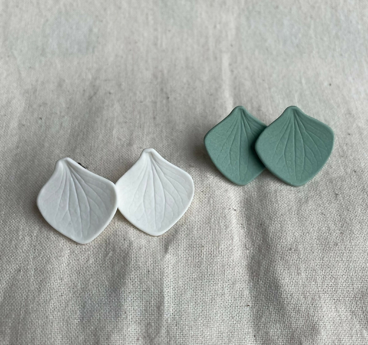 Paire de clous d’oreille en porcelaine blanche et kaki, forme pétale avec veinage
