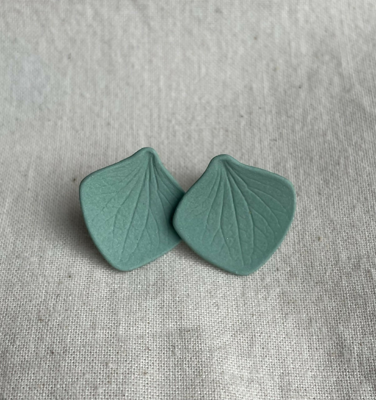 Paire de clous d’oreille en porcelaine kaki, forme pétale, veinage de feuille