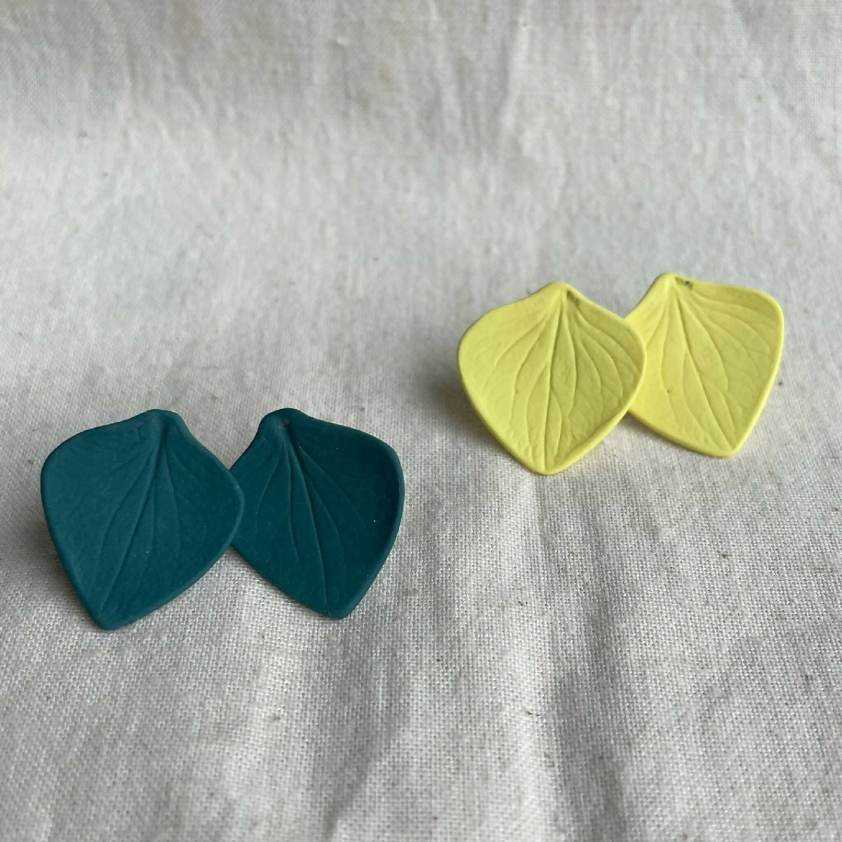 Boucles d’oreilles en porcelaine : paire vert foncé et paire jaune, forme feuilles.