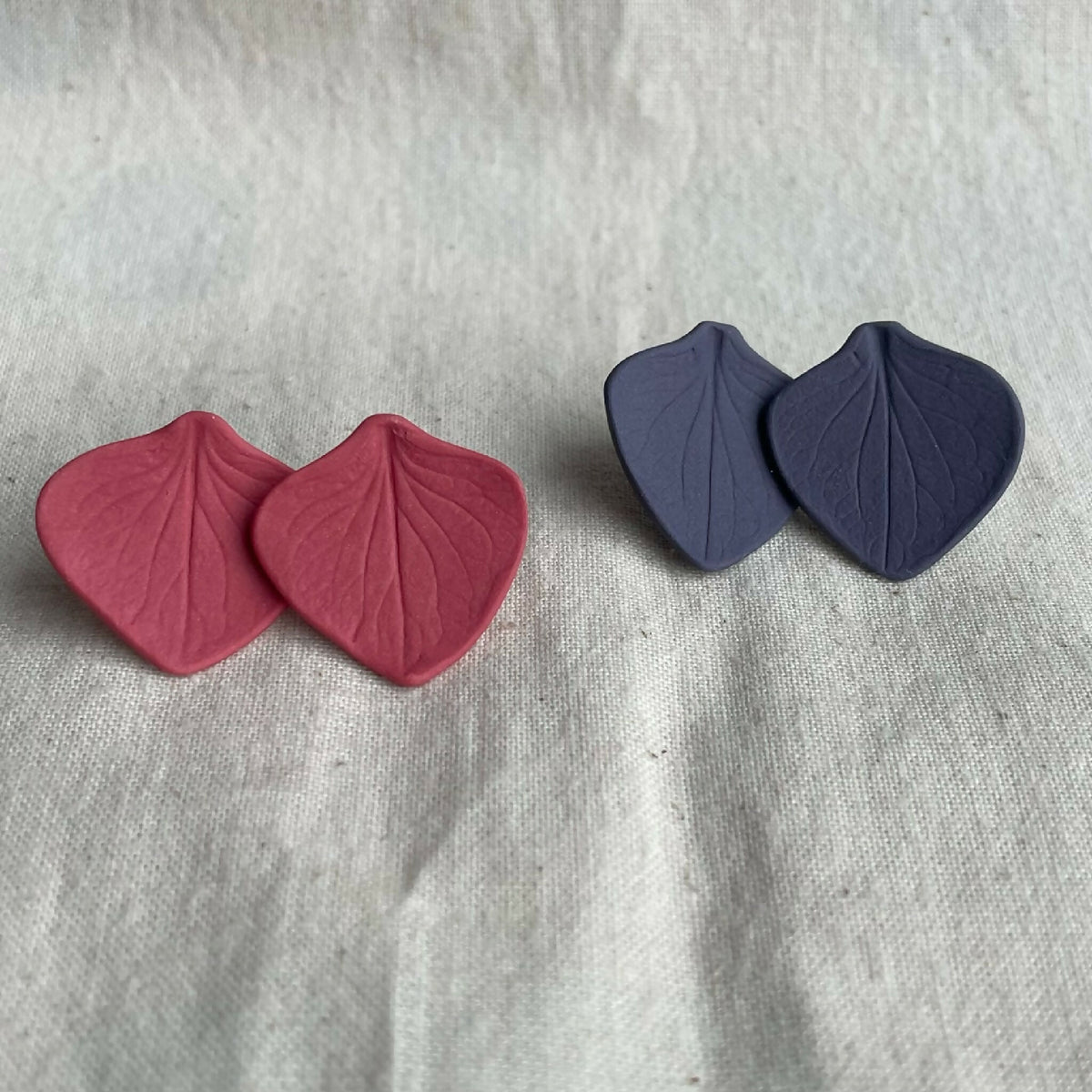 Clous d’oreille en porcelaine Marie Courtillat, paires rouge et violette, cœur nervuré