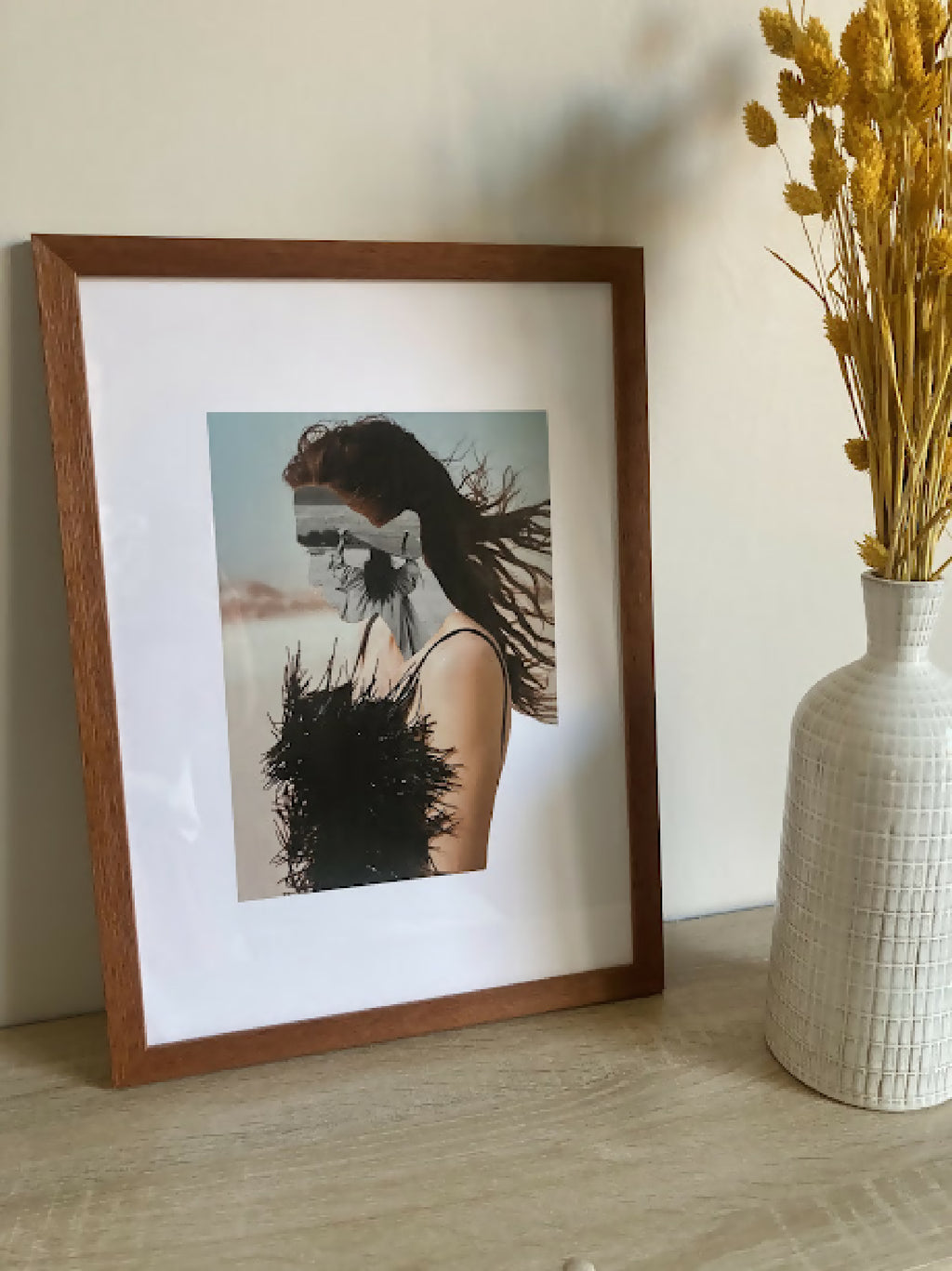 Collage encadré : cadre en bois brun, portrait de femme à robe noire en plumes