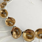 Bracelet : médaillons dorés perforés sur cordon noir