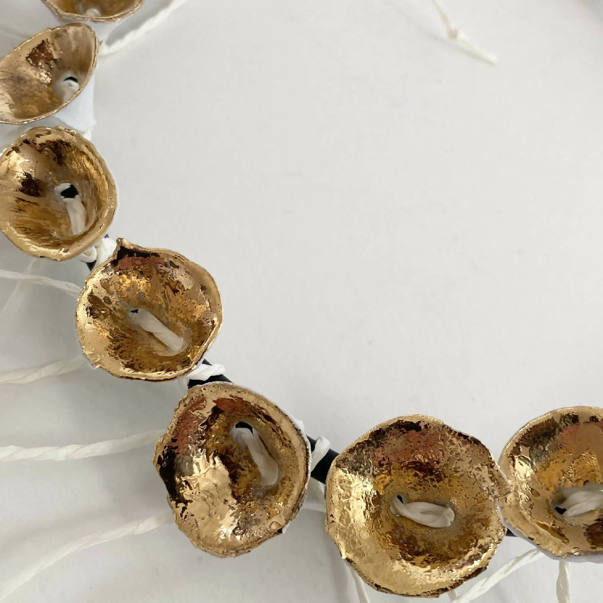 Bracelet : médaillons dorés perforés sur cordon noir