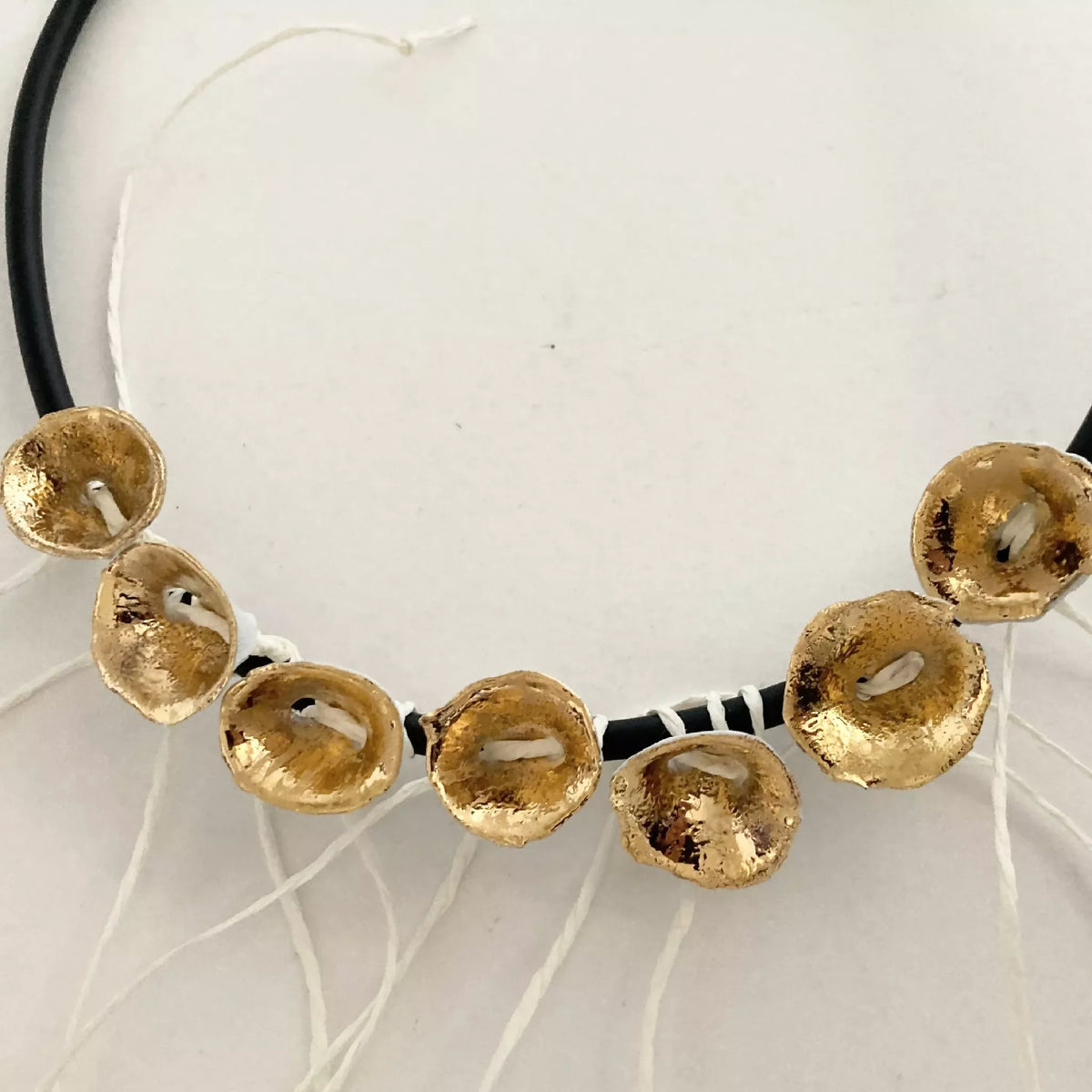 Bracelet à cordon noir et médaillons dorés, vue rapprochée