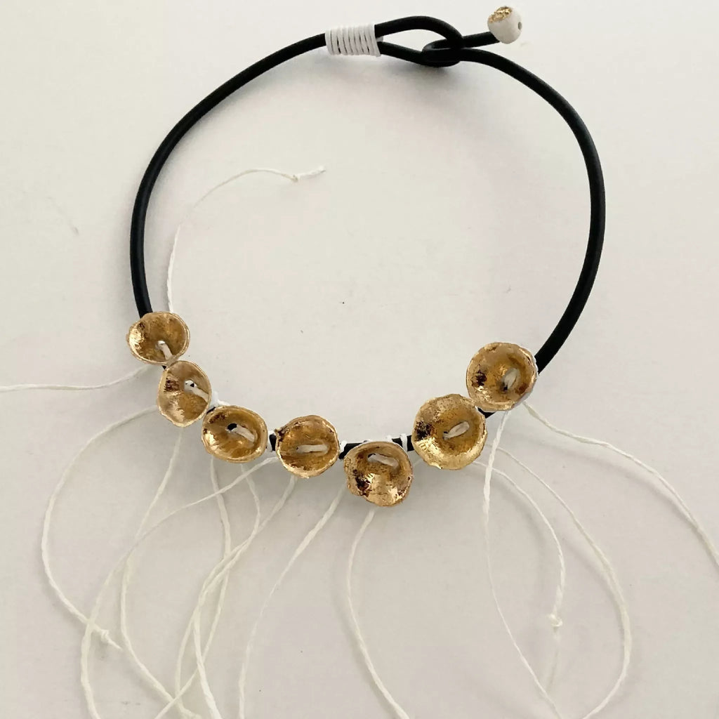Bracelet cordon noir et médaillons dorés avec liens blancs