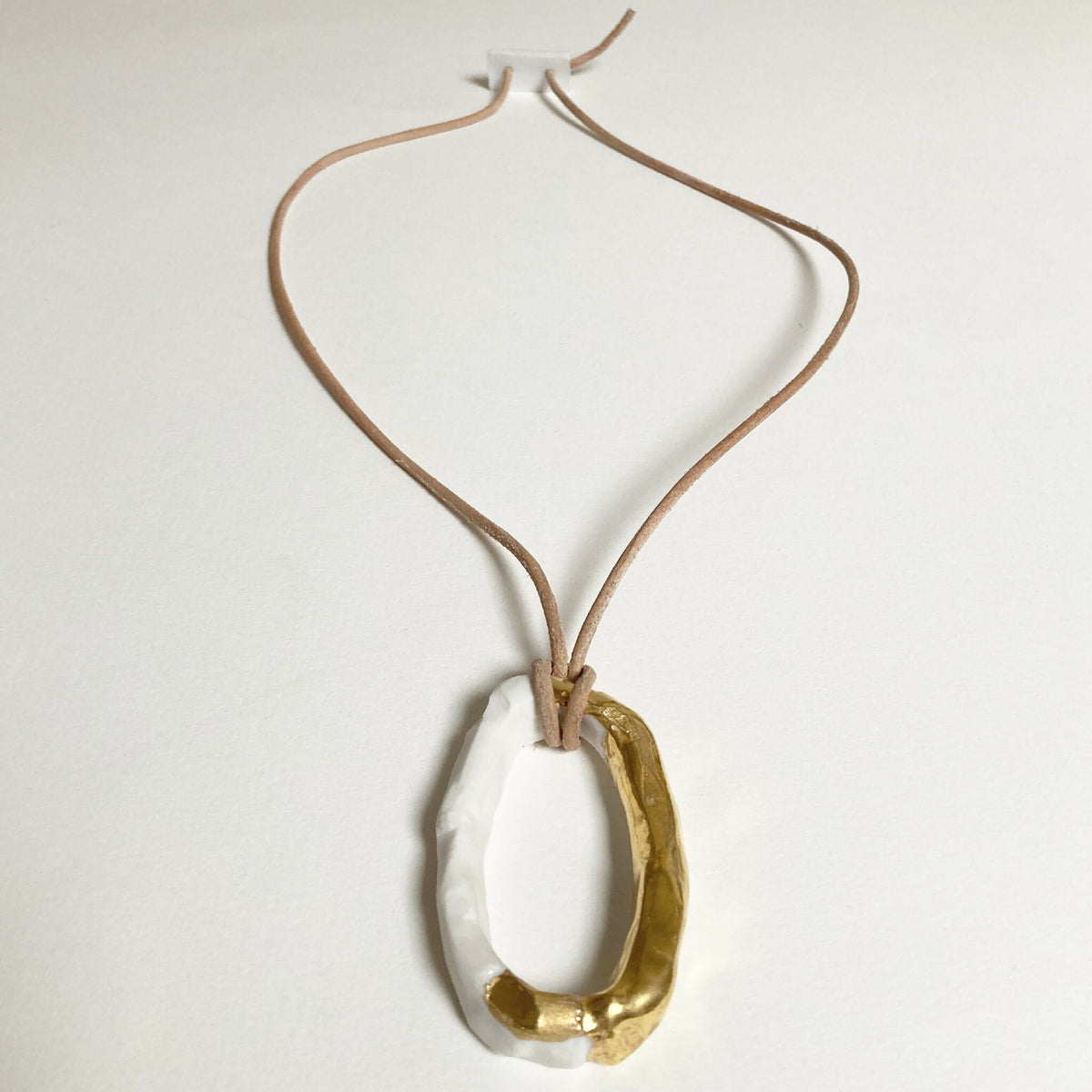 Collier avec pendentif anneau porcelaine blanc et doré, cordon brun noué