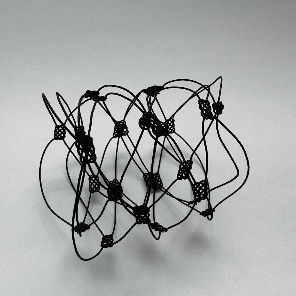 Bracelet en fil noir multibrins avec perles et motifs géométriques