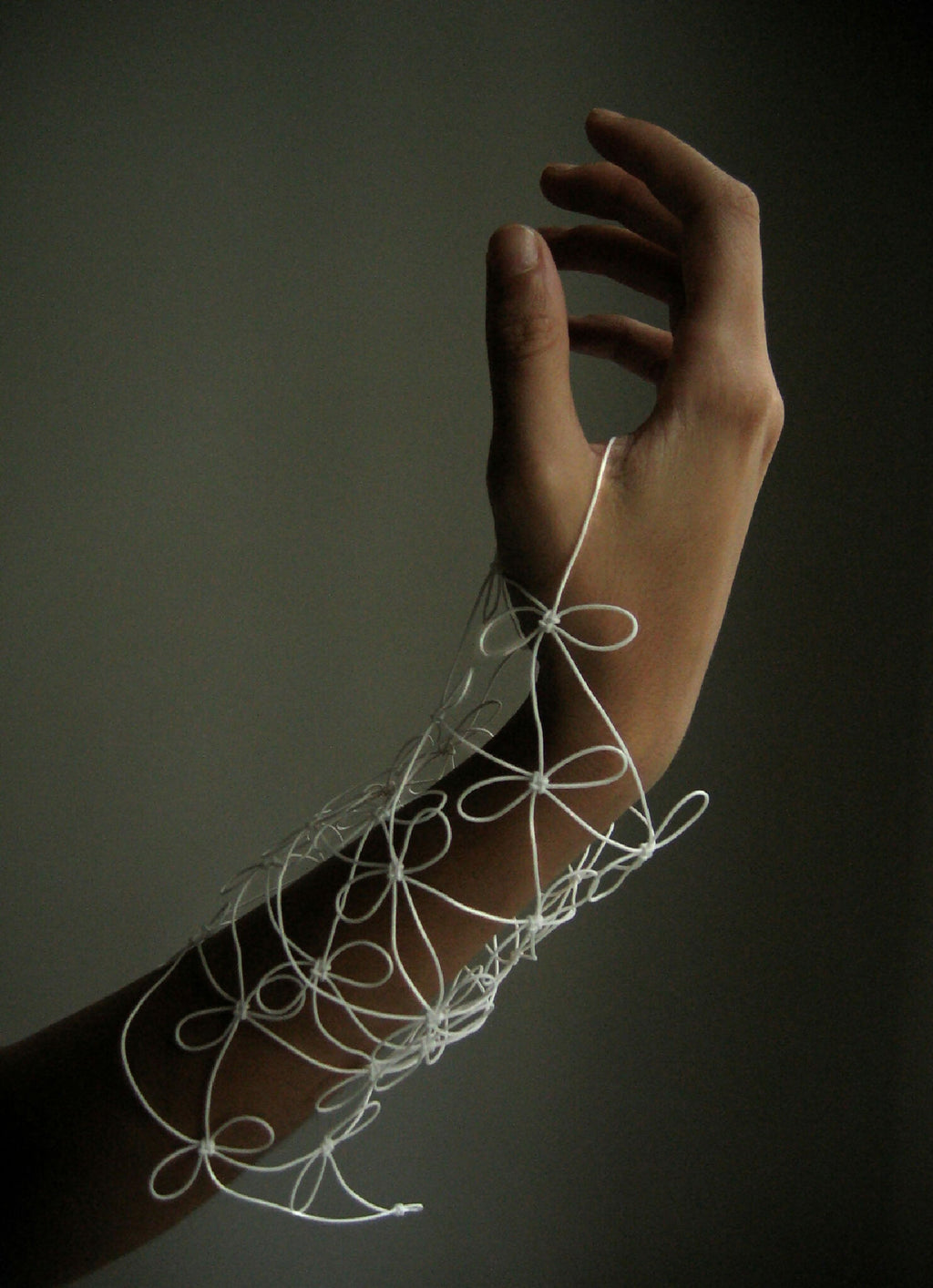 Bracelet en fil blanc fin, motifs bouclés et perles