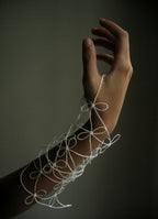 Bracelet en fil blanc fin, motifs bouclés et perles