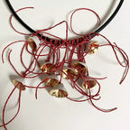 Collier cordon noir, pendentifs fleurs dorées et fils rouges torsadés