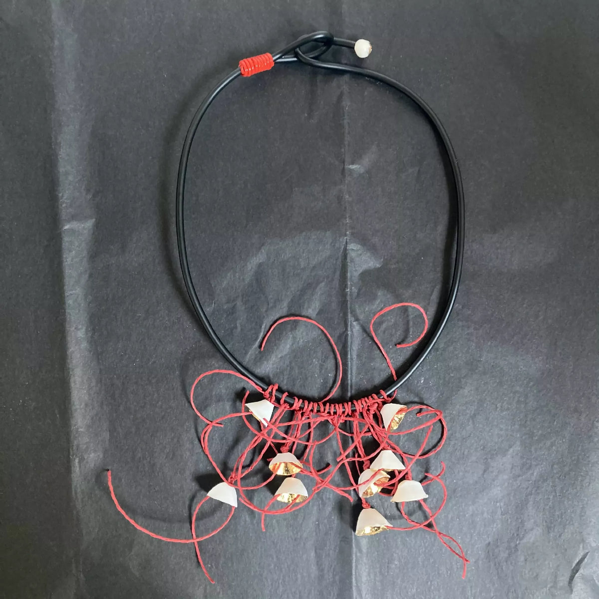Collier cordon noir, pendentifs fleurs dorées et fils rouges