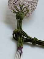 Collier en soie tulipe : nœud torsadé vert et pendentif tissu mauve pailleté.