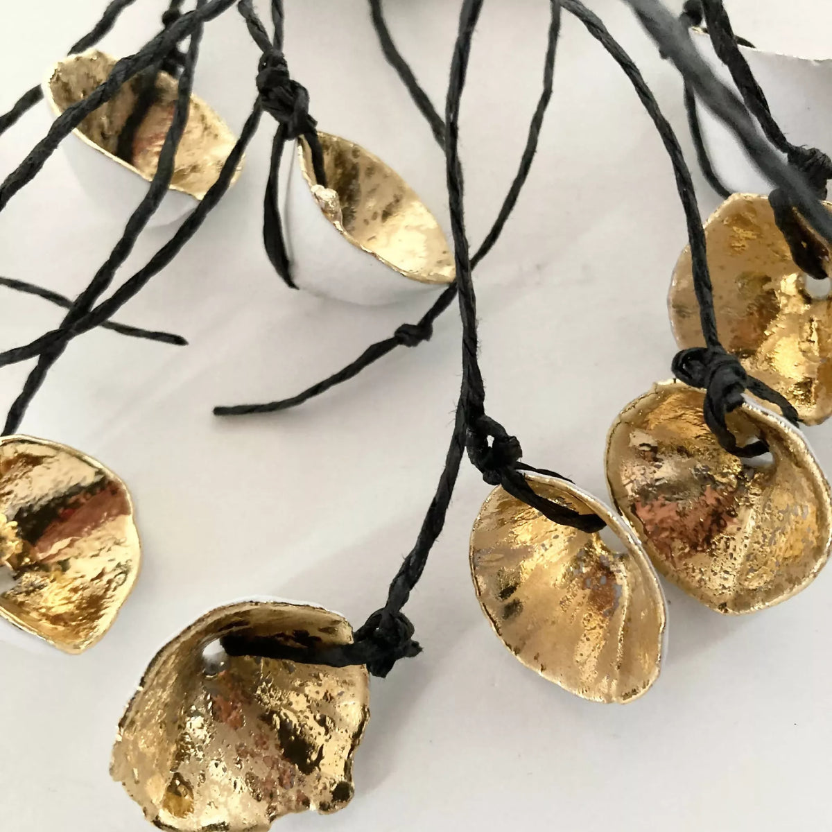 Collier : pendentifs métal doré sur cordon noir noué