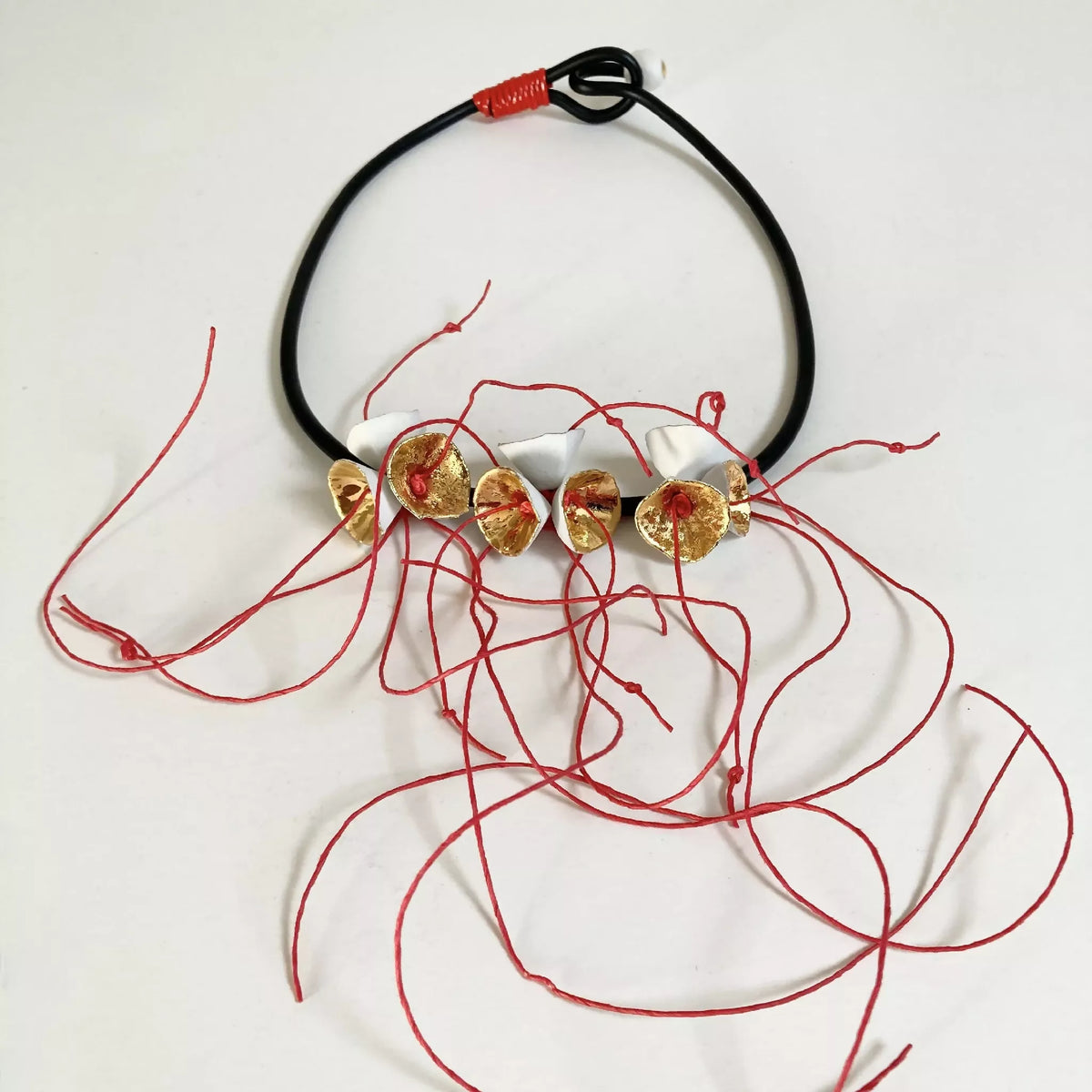 Collier à cordon noir avec fleurs dorées et fils rouges décoratifs