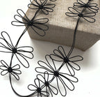 Collier de fleurs de prunier noir avec fleurs en fil noir sur cordon fin incurvé.