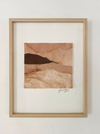 Collage textile encadré, paysage superposé beige et brun, signature en bas à droite.