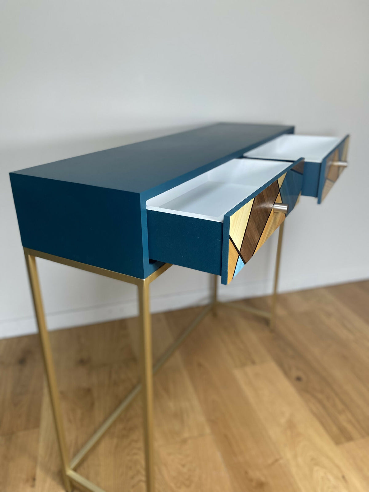 Console en bois clair, plateau bleu avec tiroir latéral à motif géométrique bois et bleu.