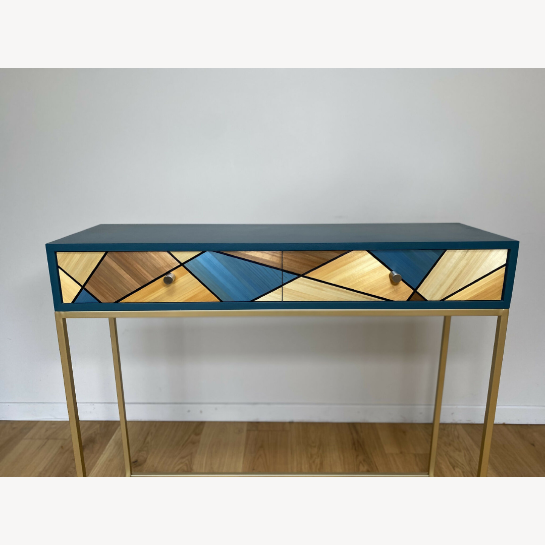 Console rectangulaire, plateau bleu et tiroir orné de losanges bois, boutons noirs.