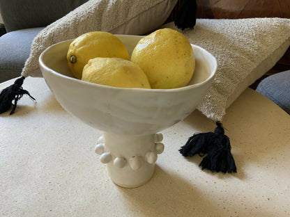 Coupelle en céramique blanche remplie d’agrume jaune