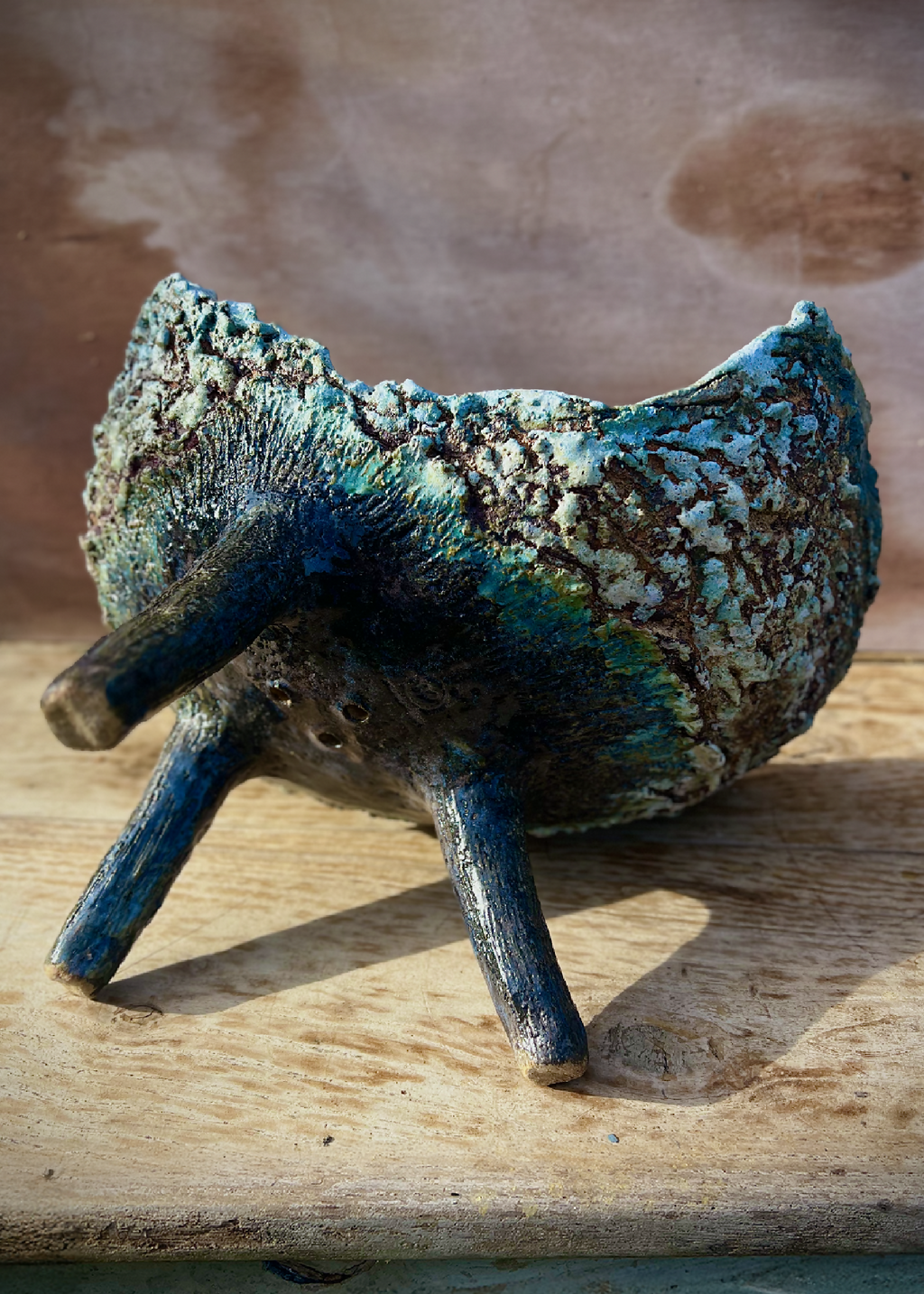 Coupe ou jardinière tripode en céramique patinée bleu, vue latérale, trois pieds et bord ondulé.