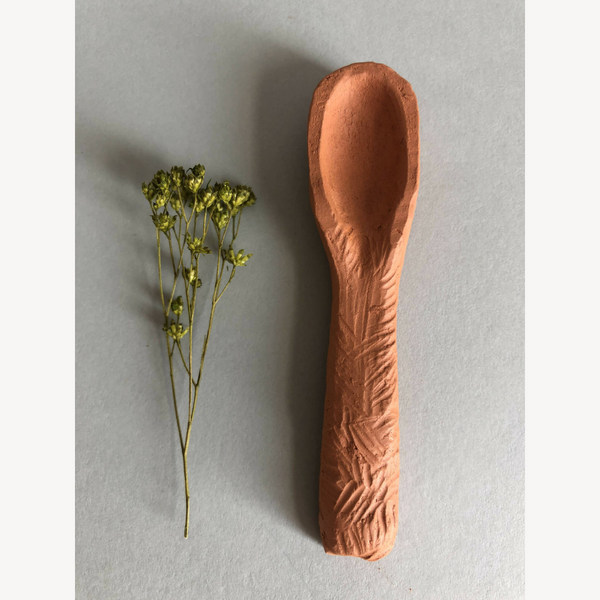 Cuillère à thé brun cuivré, grand bol ovale et manche texturé.