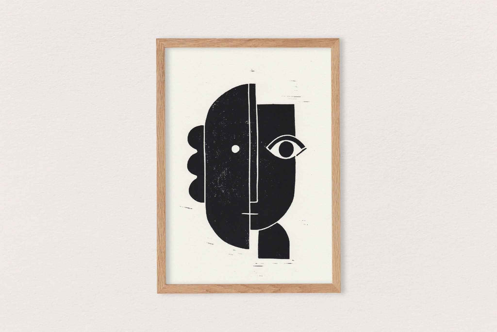 Linogravure encadrée, visuel abstrait noir et blanc avec lignes fines, cadre bois clair.