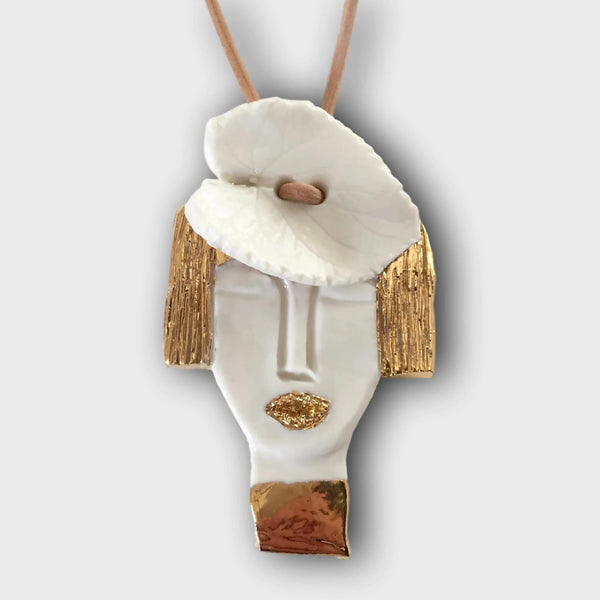 Pendentif en porcelaine blanche, finitions dorées et visage sculpté, cordon beige