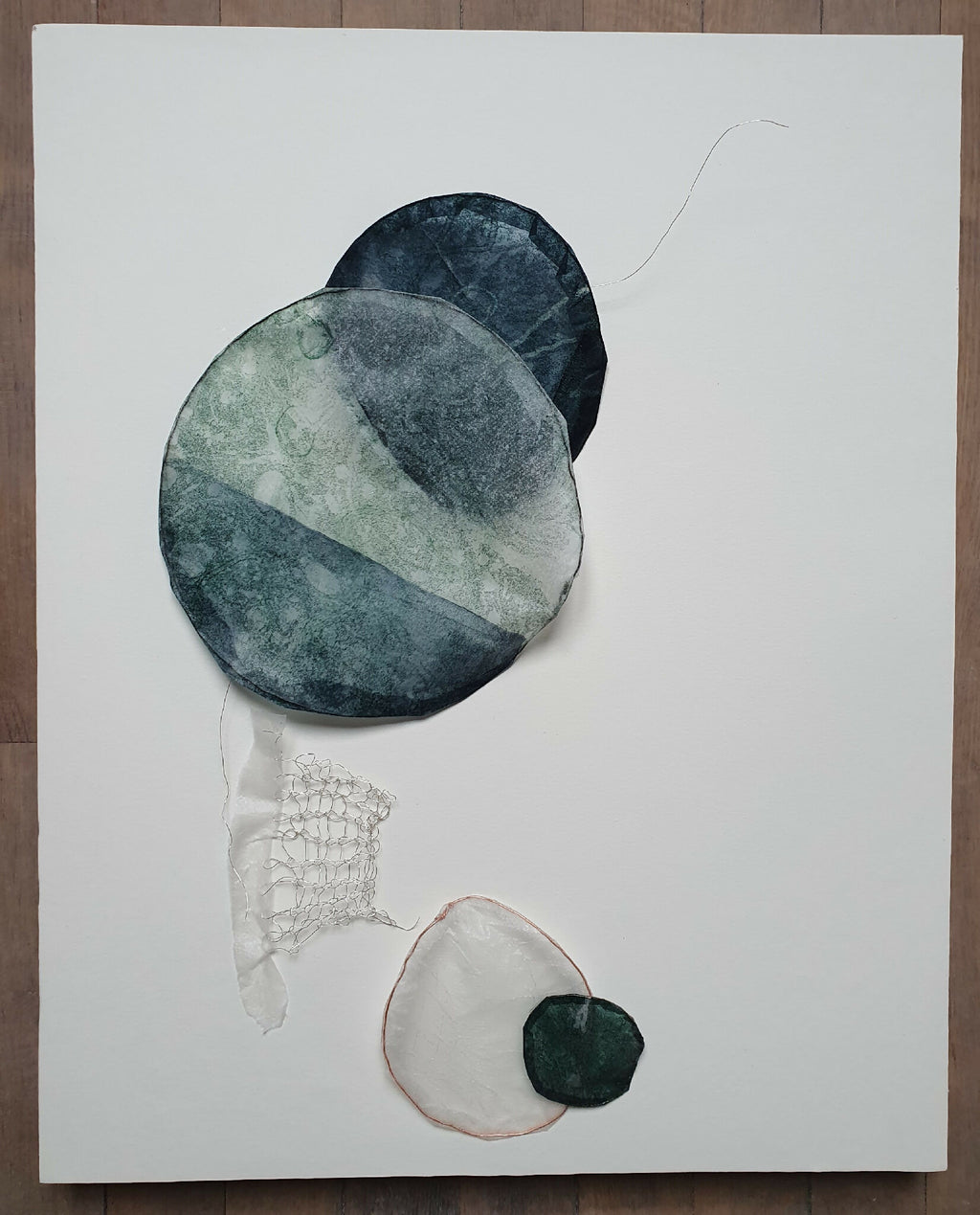 Bulle décorative en collage, formes rondes bleu-vert et gris, éléments suspendus au fil