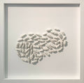 Tableau encadré en relief avec motif ondulé en éléments blancs, vue rapprochée