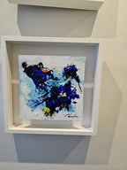 Peinture abstraite bleu et noir à éclats jaunes, dans un cadre blanc en niche