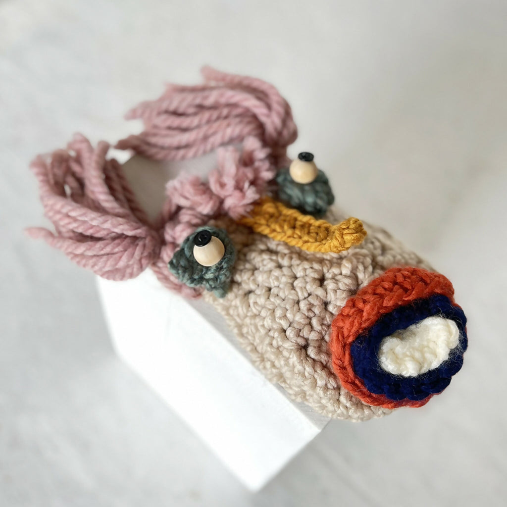 Pochette hibou Julie crochet beige, gros plan sur le visage et le motif enroulé