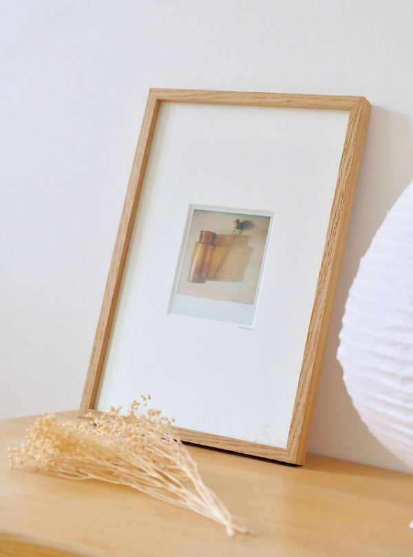 Cadre photo en bois clair avec passe-partout blanc et photo style Polaroïd