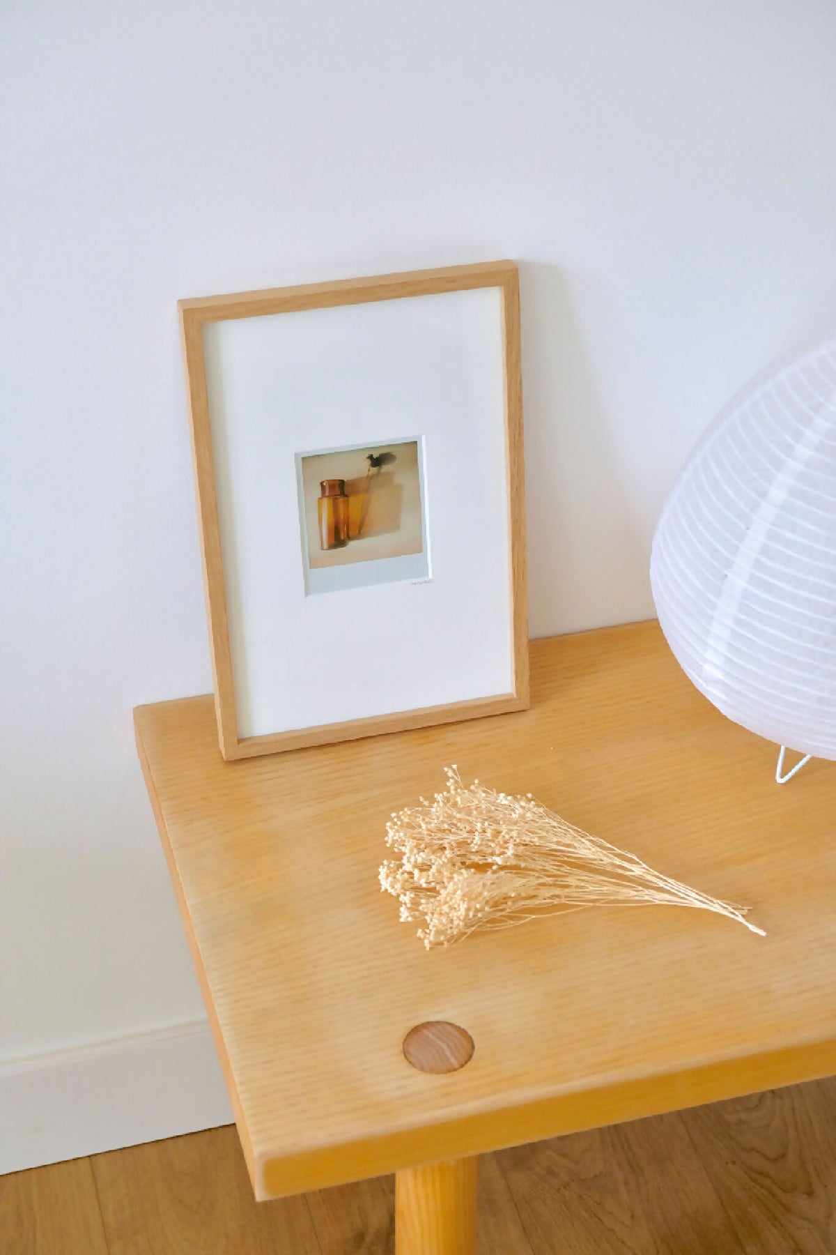 Cadre photo en bois clair avec photo style Polaroïd et passe-partout blanc