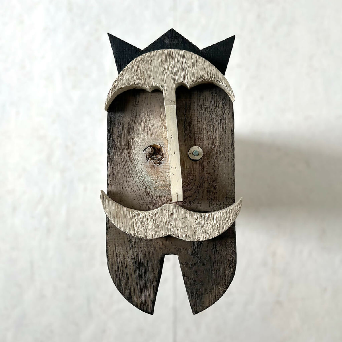 Décoration murale en bois en forme de moustache, face avant, tons clairs et foncés.