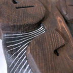Détail de tissu rayé noir et blanc sur pièce en bois foncé